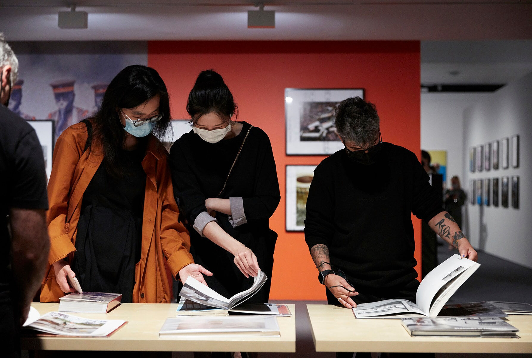 Visitors to MGA - Monash Gallery of Art viewing photobooks at the launch of the exhibition ‘Not standing still- new approaches in documentary photography', 2021. Photo by Zan Wimberley.