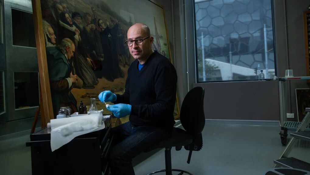 NGV's head of conservation Michael Varcoe-Cocks working on the painting The Pilgrim Fathers.CREDIT:SIMON SCHLUTER